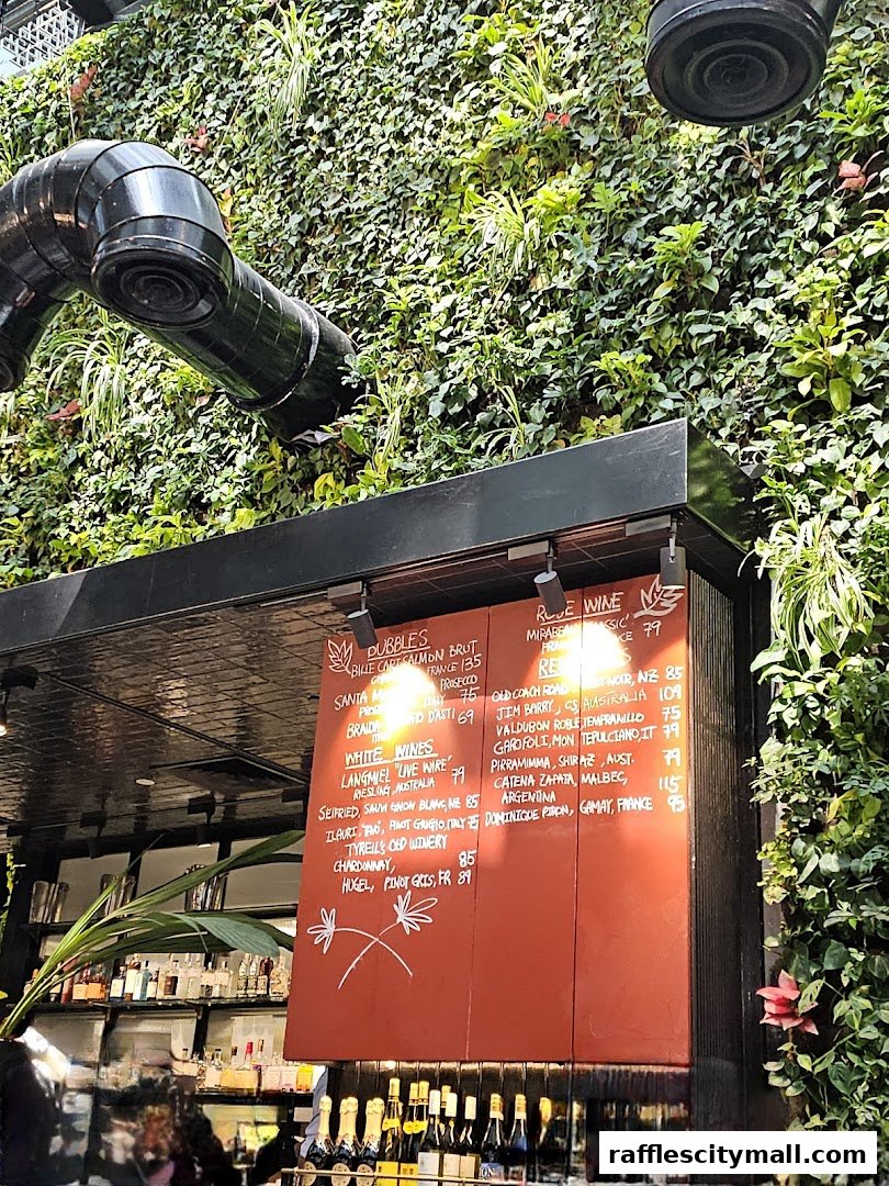 A menu board with wine selections displayed against a lush green wall.