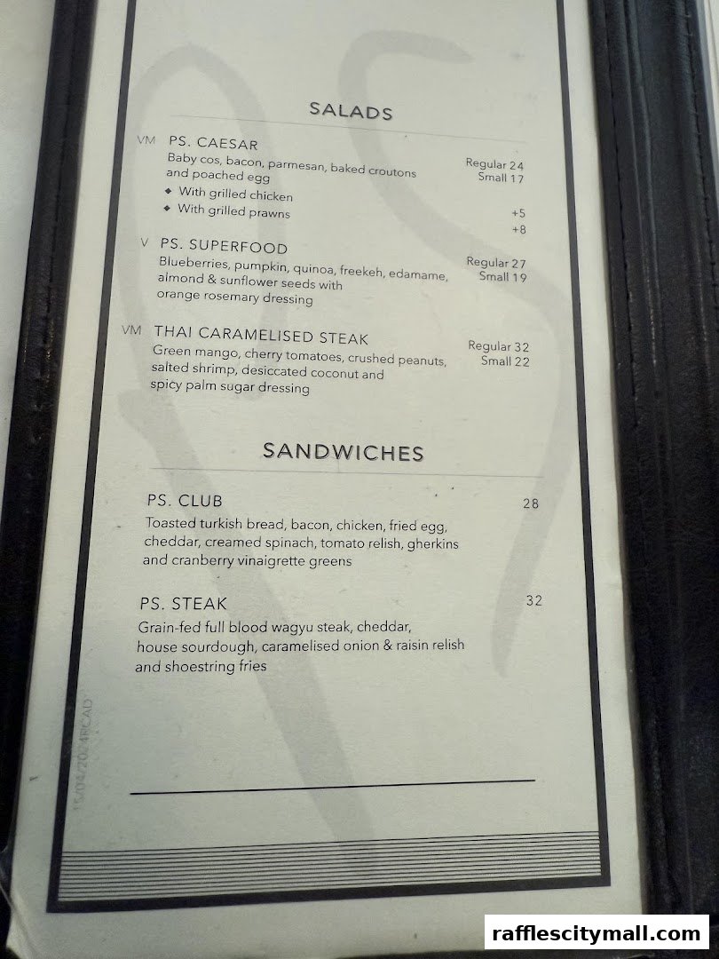 A menu from PS.Cafe Raffles City featuring salads and sandwiches with descriptions and prices.