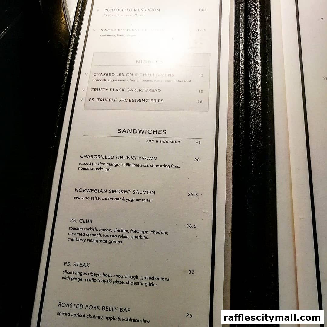 A close-up view of a restaurant menu featuring sandwiches and nibbles.