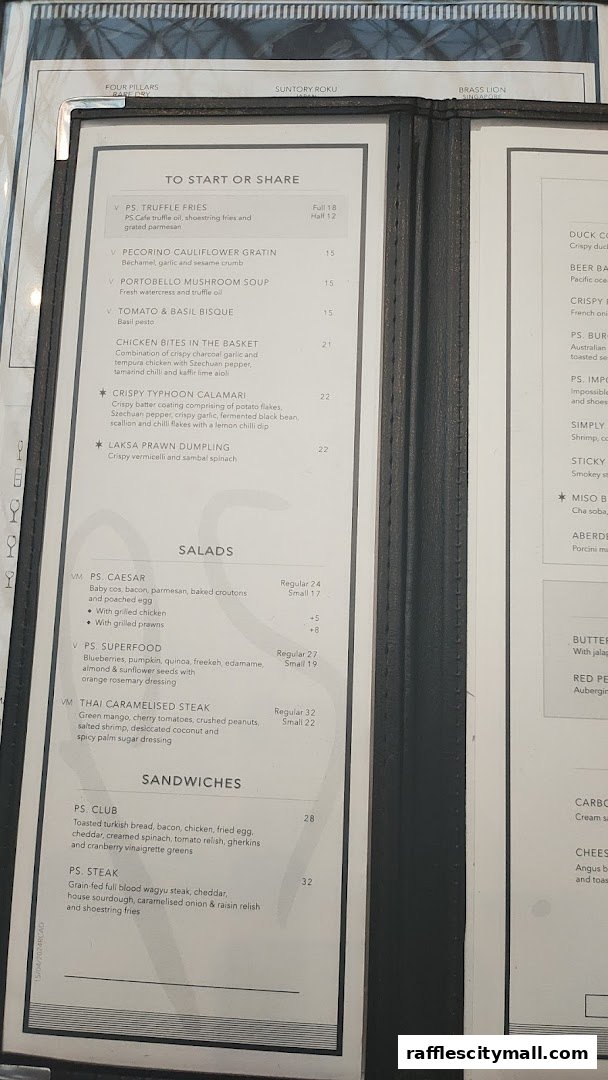 A close-up view of a restaurant menu featuring appetizers, salads, and sandwiches.