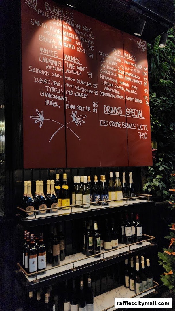 A red menu board displays wine and drink specials, with shelves of wine bottles below.
