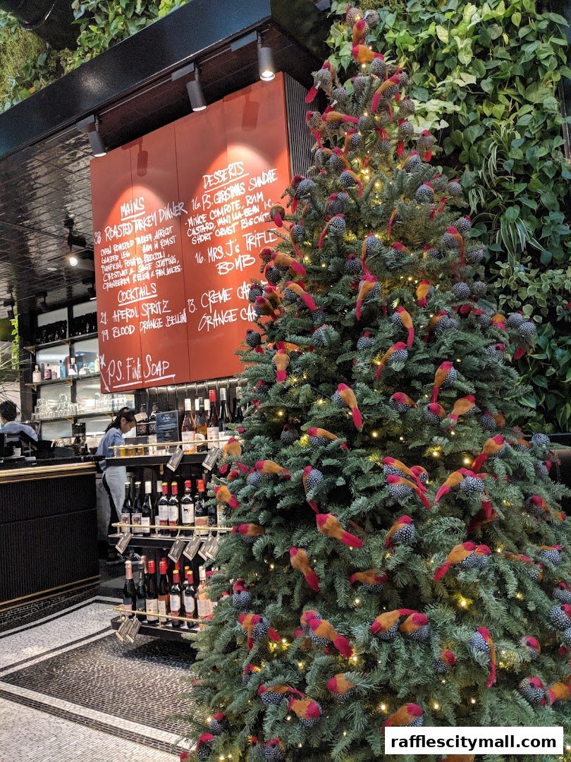 A festive Christmas tree decorated with bird ornaments stands next to a menu board and wine display.