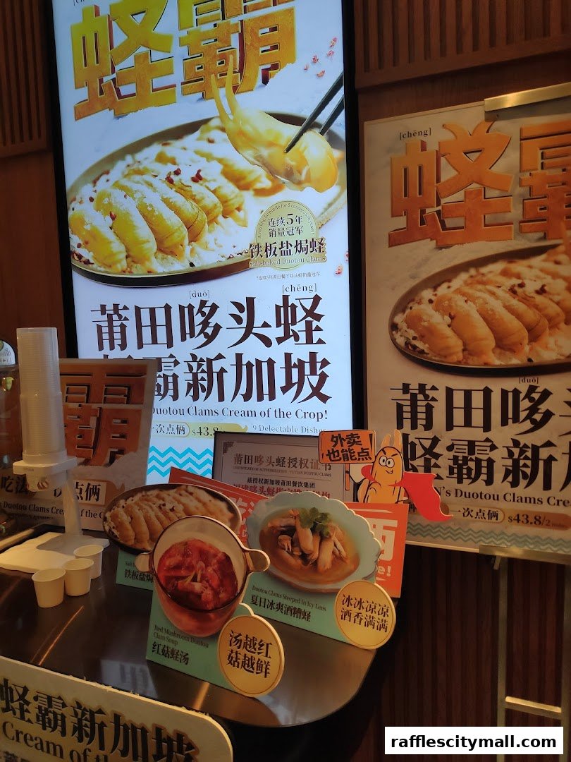 Promotional posters and displays showcasing signature clam dishes at PUTIEN Raffles City.