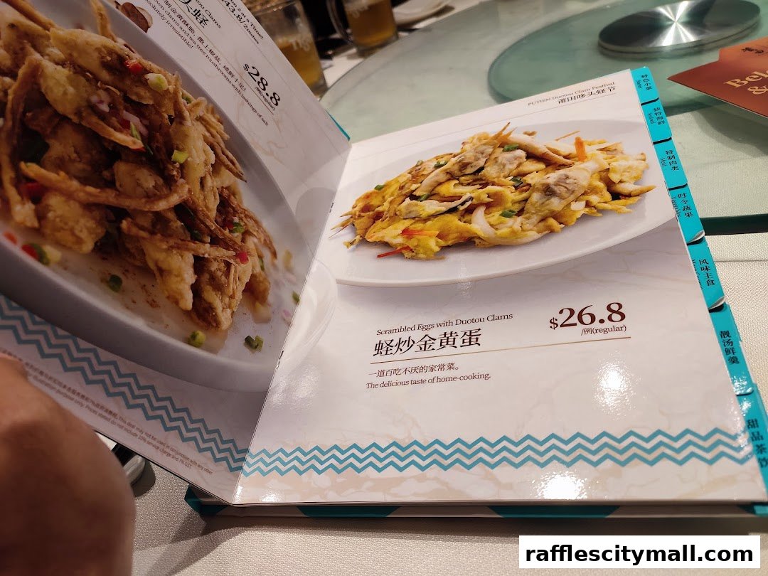 A menu page from PUTIEN featuring two dishes: fried seafood and scrambled eggs with clams.