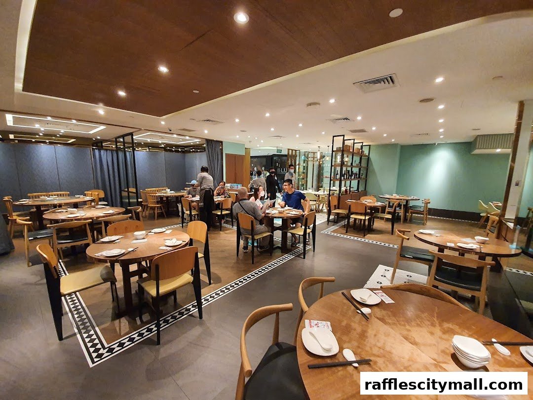 Interior view of a spacious restaurant with multiple dining tables and patrons enjoying their meals.