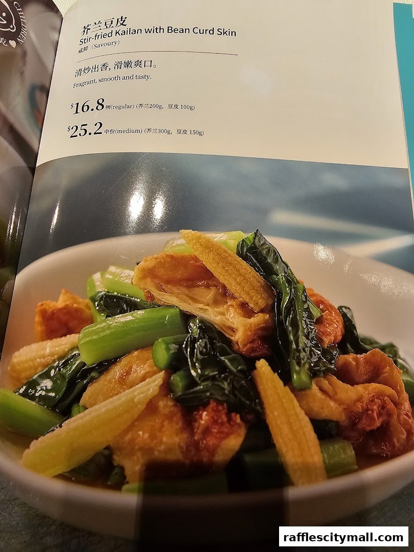 A menu item featuring stir-fried kailan with bean curd skin, with prices and descriptions.
