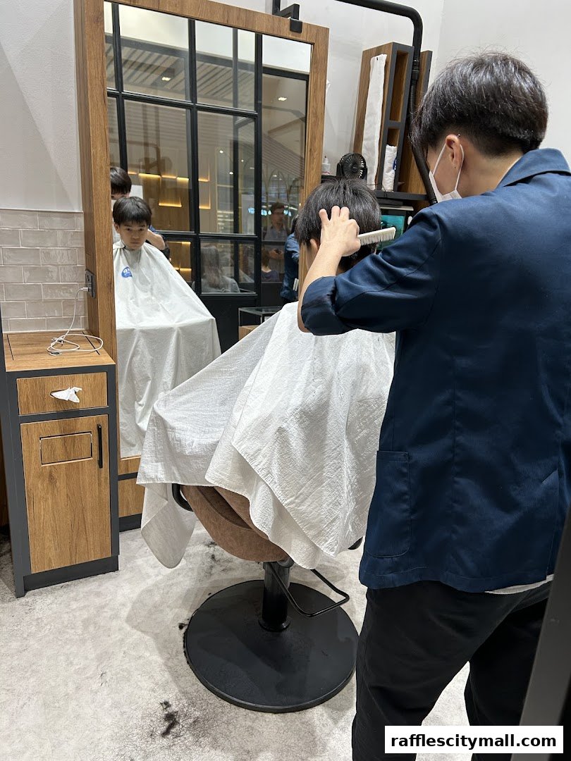 A barber is cutting a young boy's hair in a modern salon.