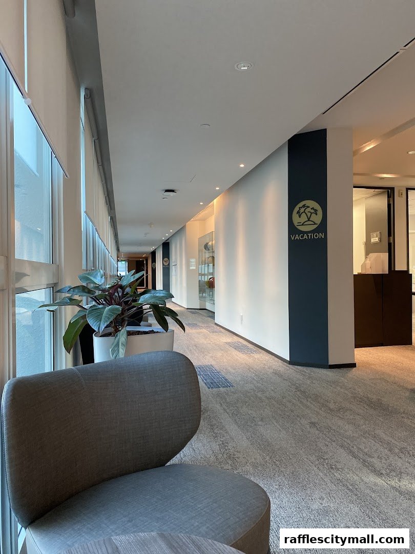 A modern office hallway with a chair, plants, and a sign that says "VACATION".