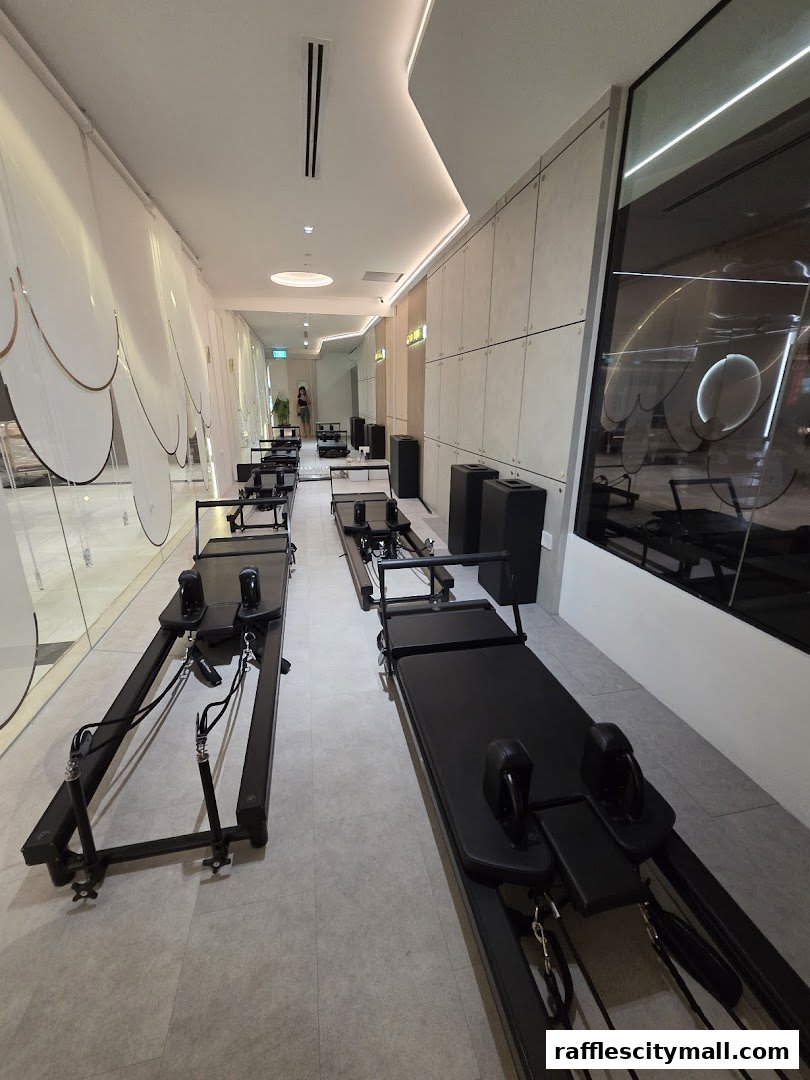Interior view of a modern yoga studio with multiple Pilates reformers.