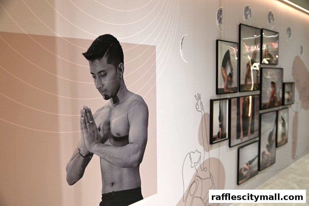 A man in a yoga pose with framed yoga photos on the wall.