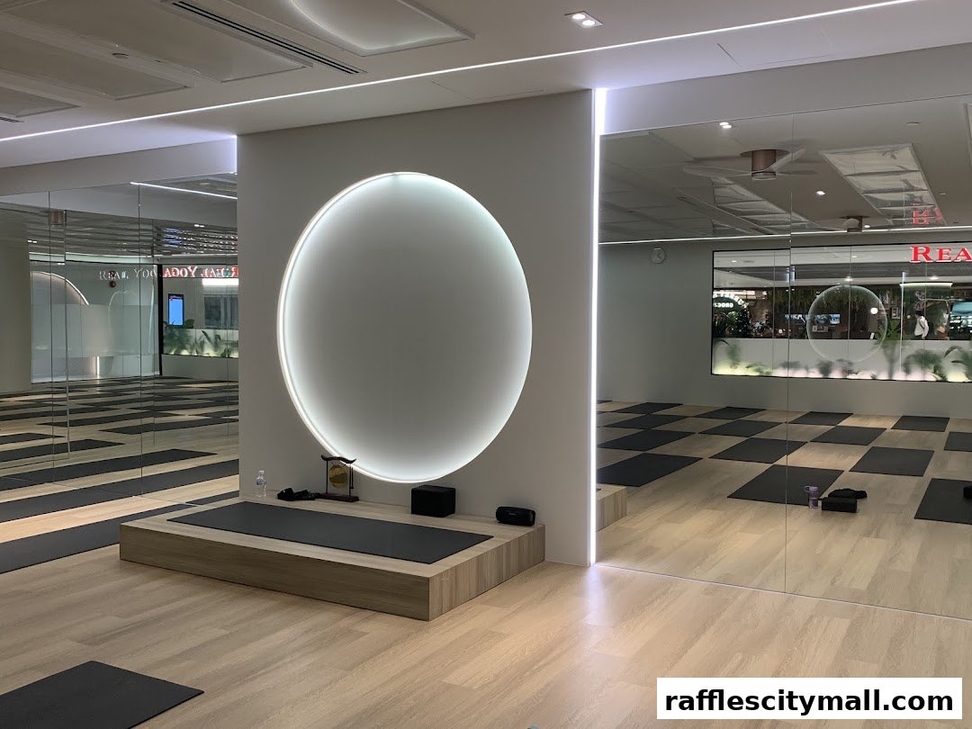 Interior of a modern yoga studio with yoga mats, mirrors, and a circular light feature.