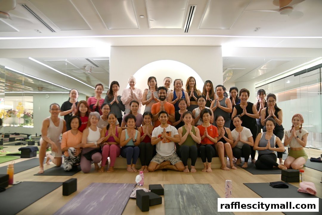 A diverse group of people posing for a photo in a bright yoga studio.