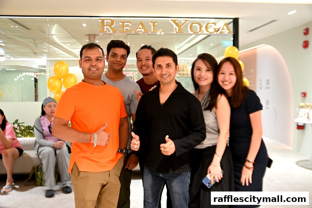 A group of people posing for a photo in front of a Real Yoga Premium store.