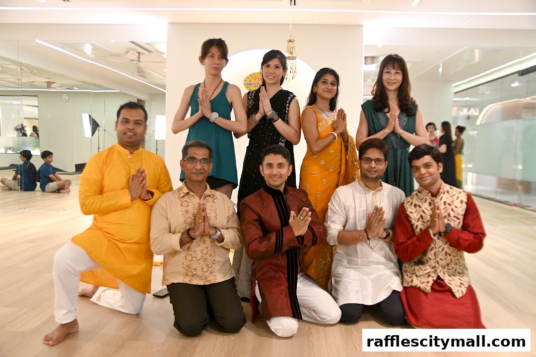 A group of people in traditional Indian attire posing for a photo in a yoga studio.