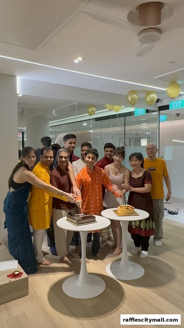 A group of people celebrating with cakes and balloons indoors.