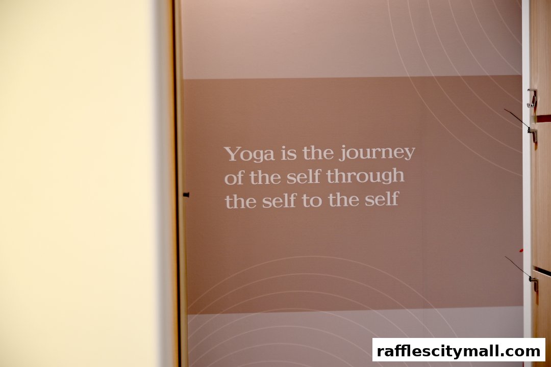 A wall with a motivational quote about yoga and a glimpse of lockers.