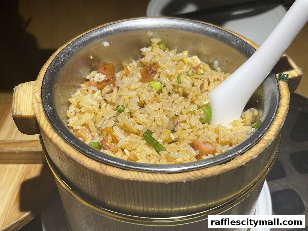A close-up shot of a delicious fried rice dish served in a wooden bucket with a spoon.