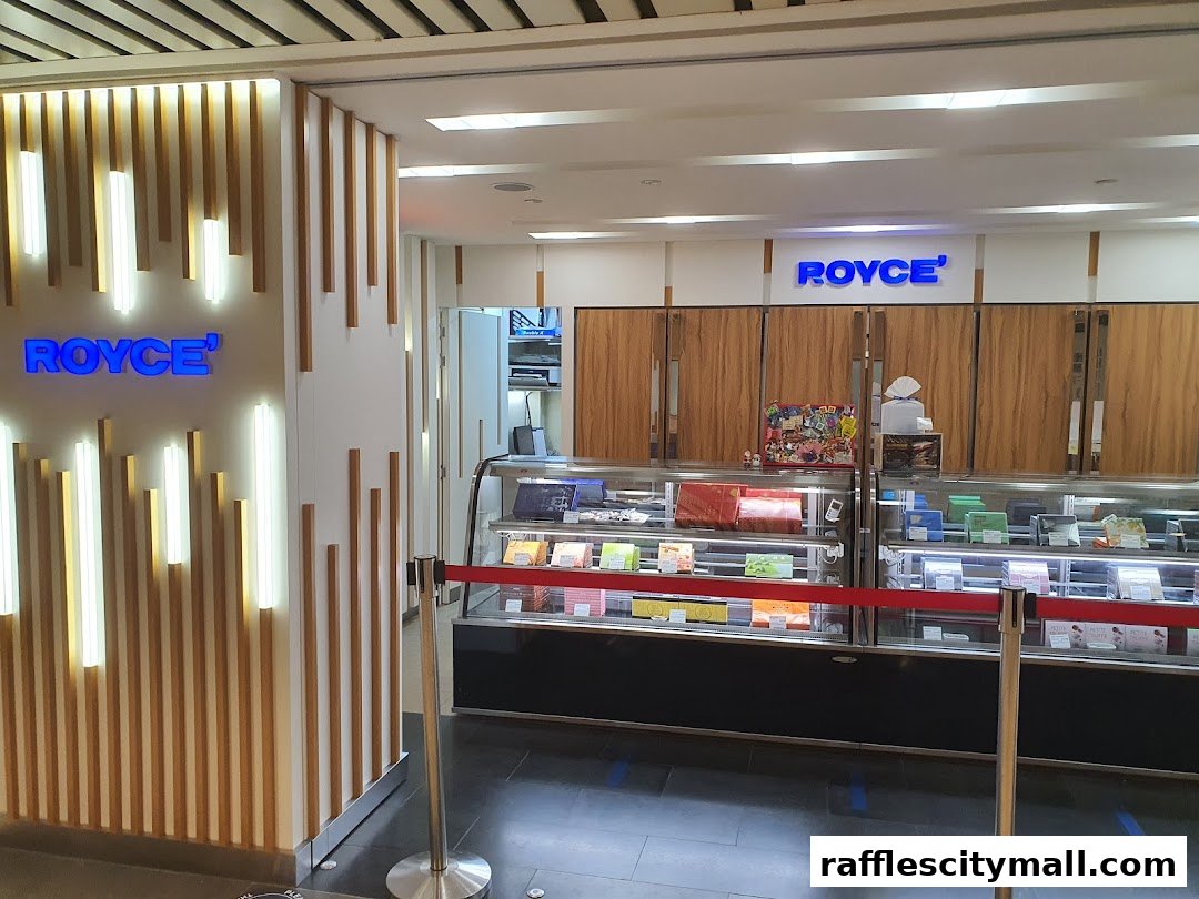 The entrance to a Royce confectionery shop with illuminated signage and display cases.