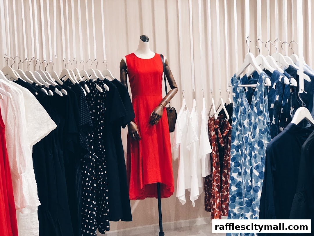 A mannequin wearing a red dress is displayed with various clothing items on hangers.
