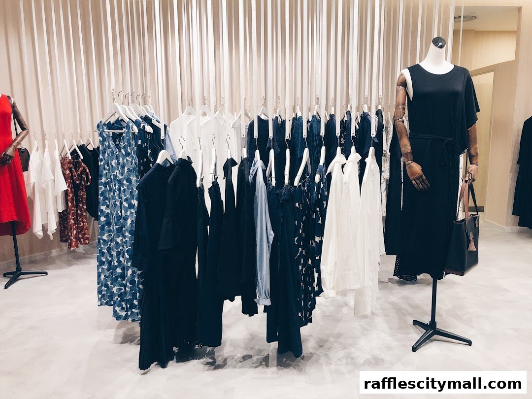 A clothing store interior with mannequins and racks of dresses and tops.