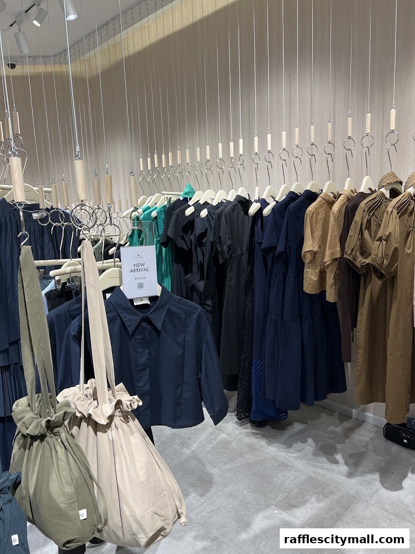 A clothing store interior with racks of dresses and bags, featuring a 'New Arrival' sign.