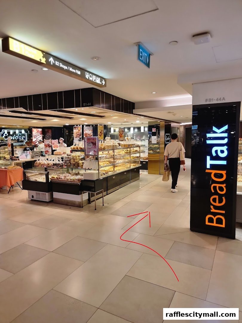 A view of a bakery shop with displays of pastries and bread, and signage.