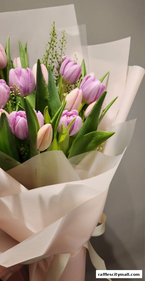 A close-up of a beautiful bouquet of pink and purple tulips with delicate greenery.