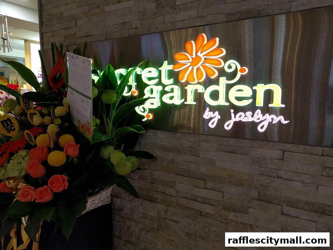 A glowing neon sign for 'Secret Garden by Jaslyn' above a basket of fresh flowers.