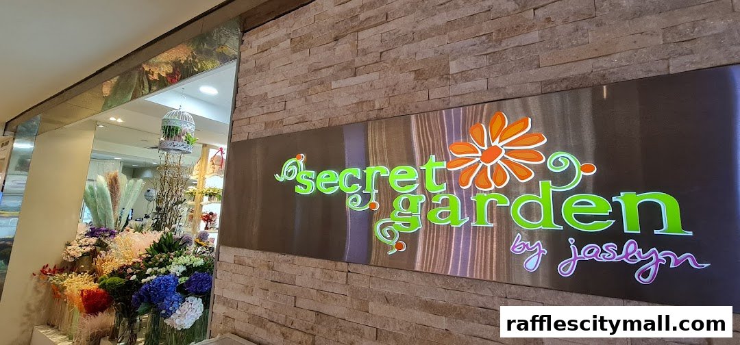The entrance to Secret Garden flower shop, featuring a prominent sign and a display of colorful flowers.