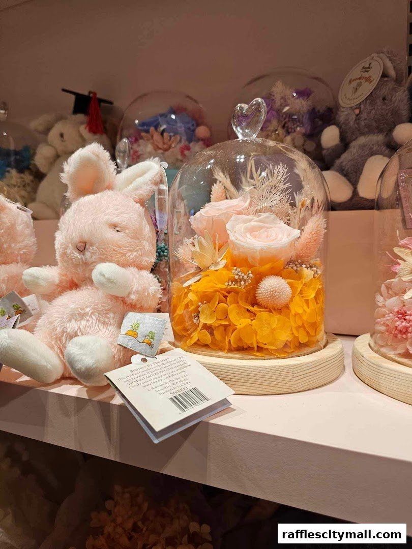 A display of preserved flower arrangements in glass domes and plush bunny toys.