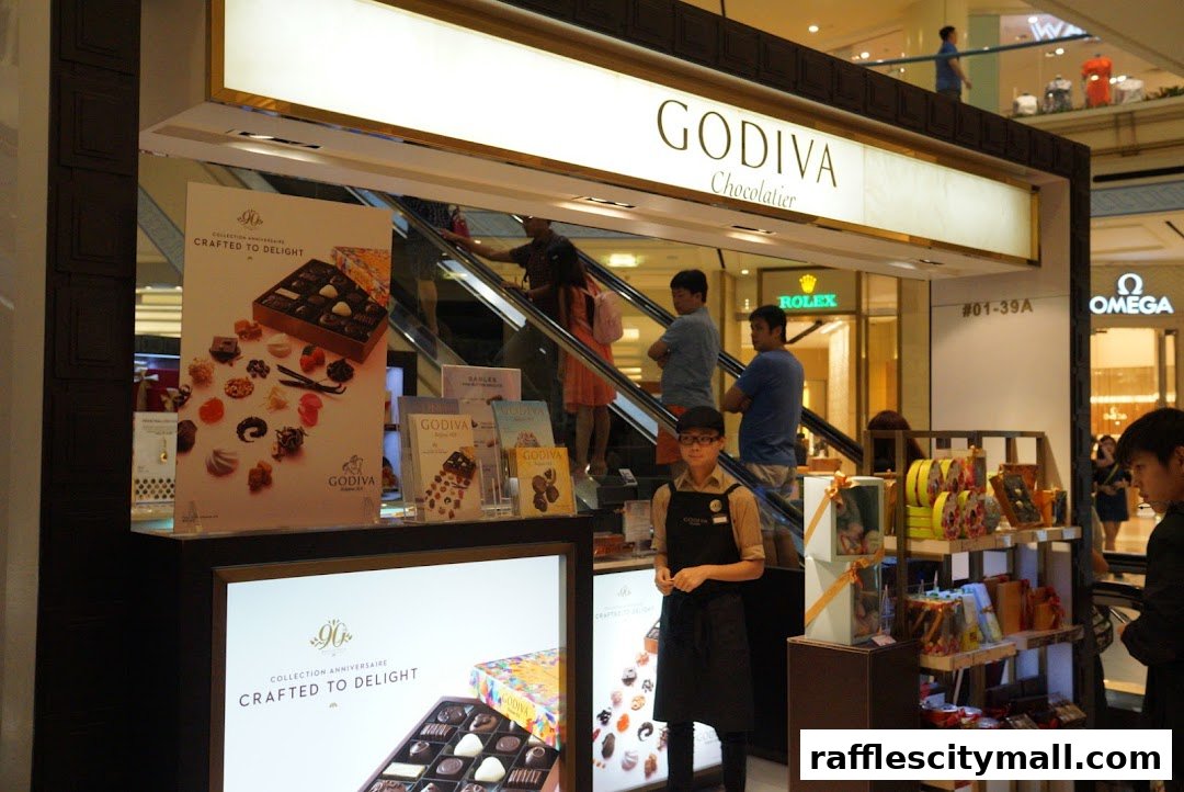 A Godiva Chocolatier shop display featuring various chocolate boxes and promotional materials.