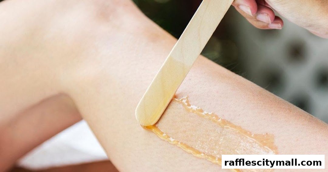 A close-up shot of a person's leg receiving a waxing treatment with a wooden spatula.