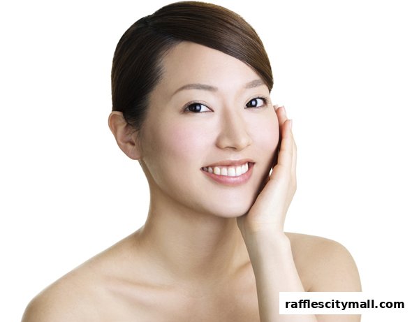 A close-up of a smiling woman's face with her hand gently touching her cheek.