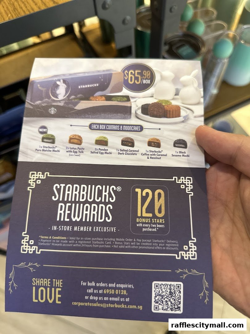 A hand holds a Starbucks promotion for mooncakes and rewards.