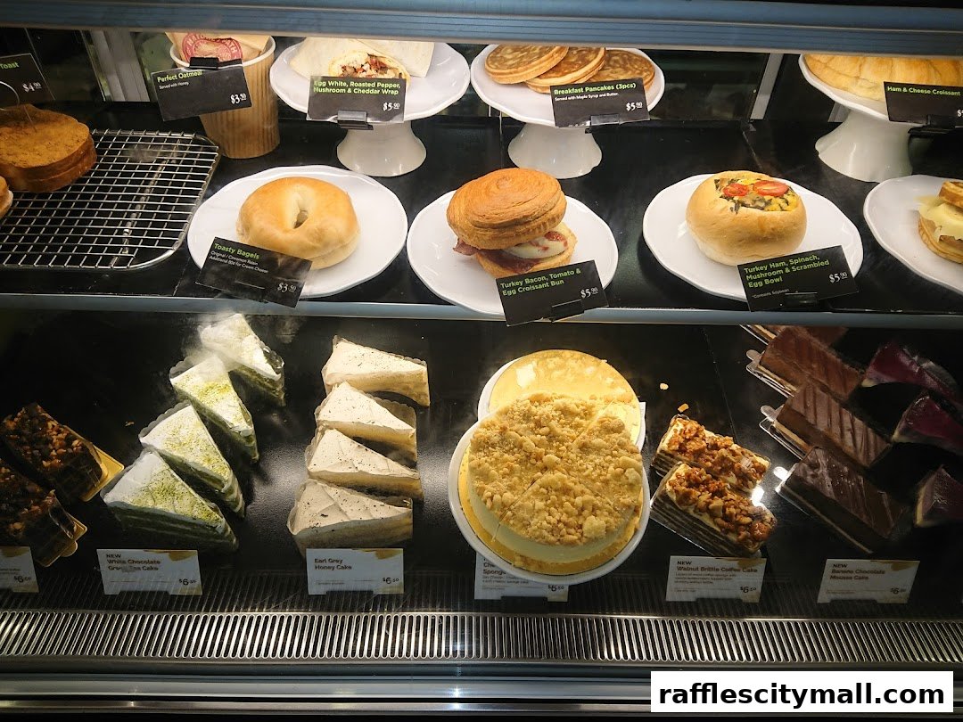 A display case filled with various pastries, cakes, and breakfast items at Starbucks.
