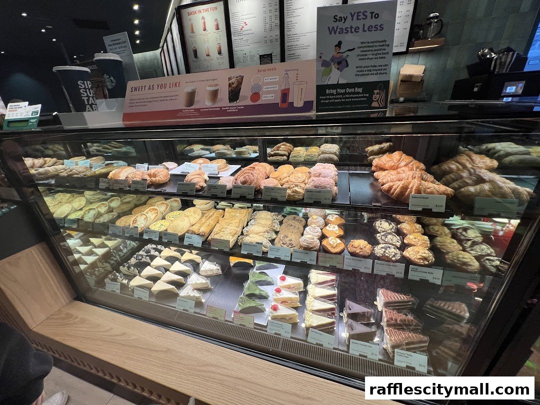 A display case filled with various pastries, cakes, and baked goods at Starbucks.