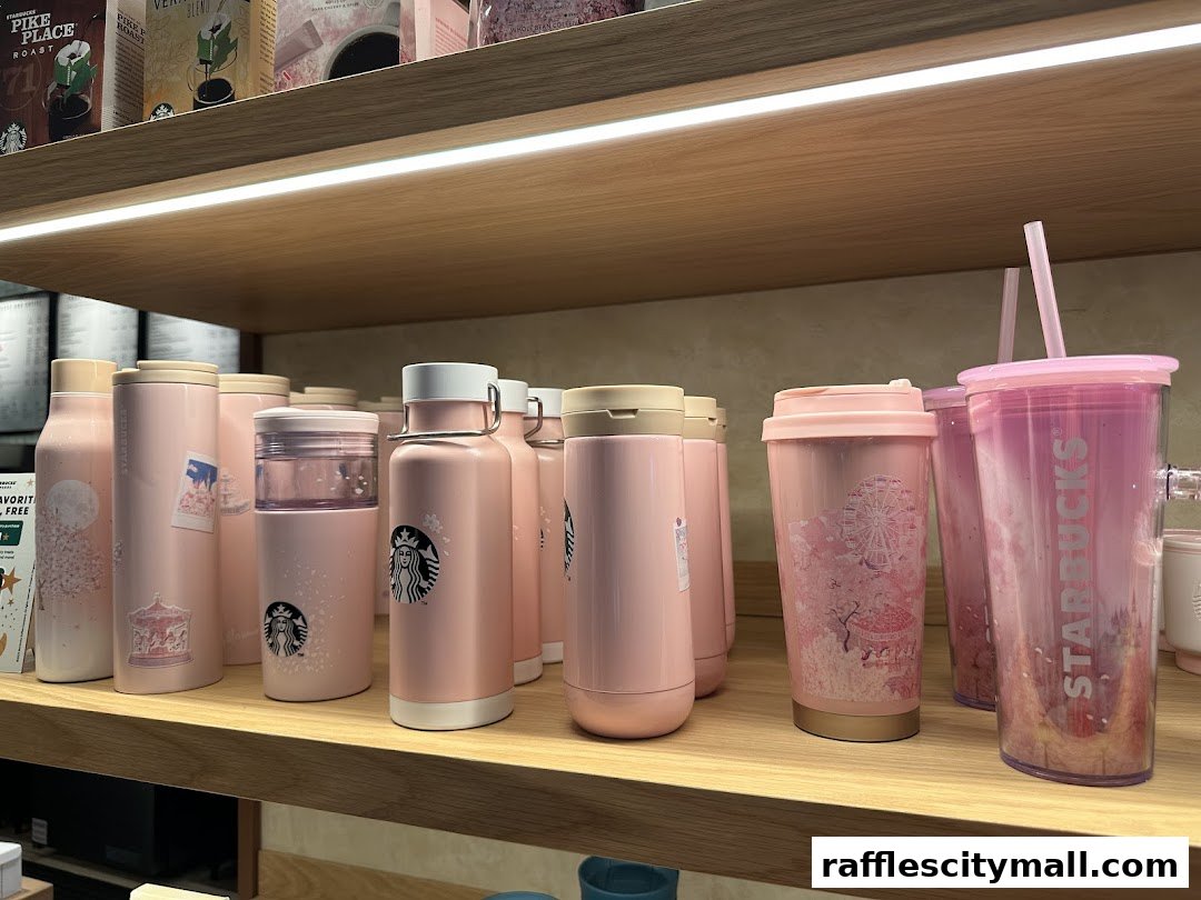 A collection of pink Starbucks tumblers and water bottles with cherry blossom and carousel designs.