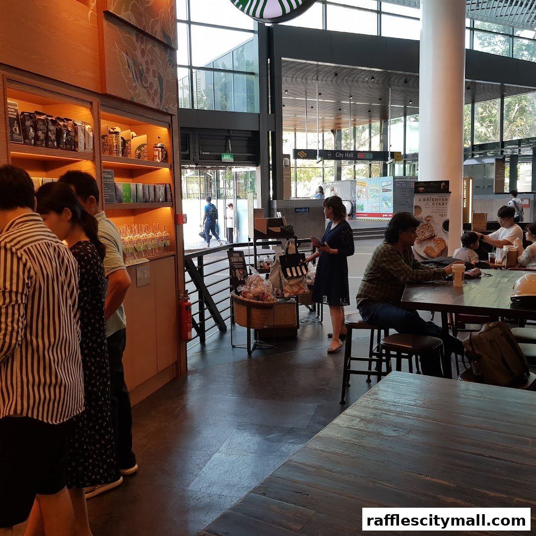 People ordering and sitting at tables inside a Starbucks with a view of a city hall station.