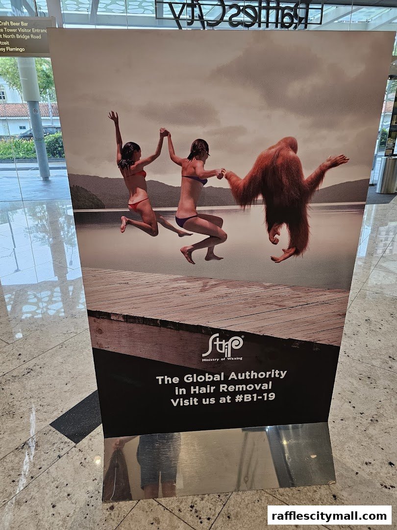 A promotional stand for Strip Ministry of Waxing featuring an orangutan and two women.