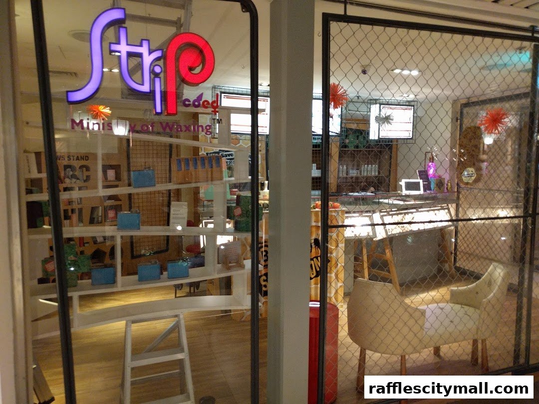 The entrance of Strip Co-Ed Raffles City, a waxing salon, with its distinctive logo and interior visible.