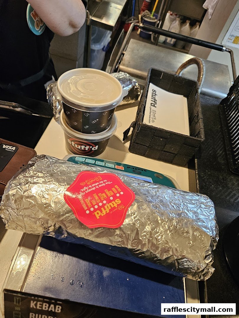A foil-wrapped kebab and two containers from Stuff'd, ready for takeaway.