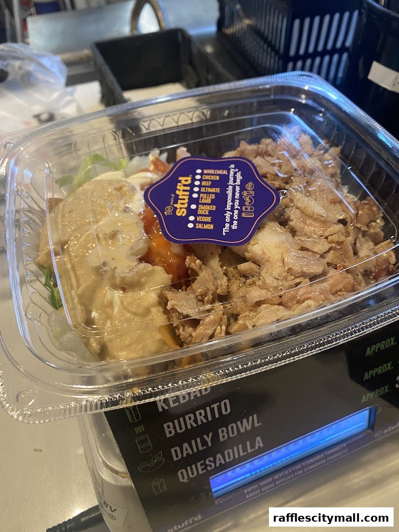 A clear plastic container filled with a delicious-looking meal from Stuff'd.