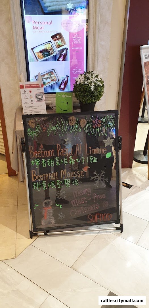 A chalkboard sign advertising Sufood's Christmas specials, including beetroot pasta and mousse.