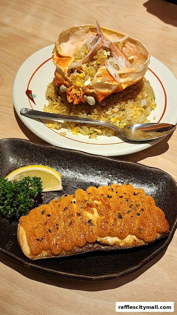 Two delicious Japanese dishes, one with fried rice in a crab shell and another with a seared fish fillet.