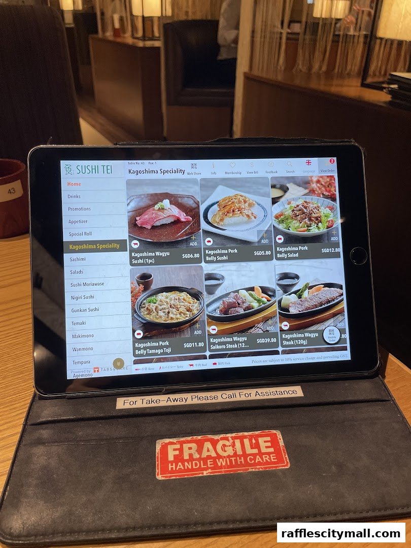 A tablet displaying the menu for Sushi Tei, featuring Kagoshima specialties.
