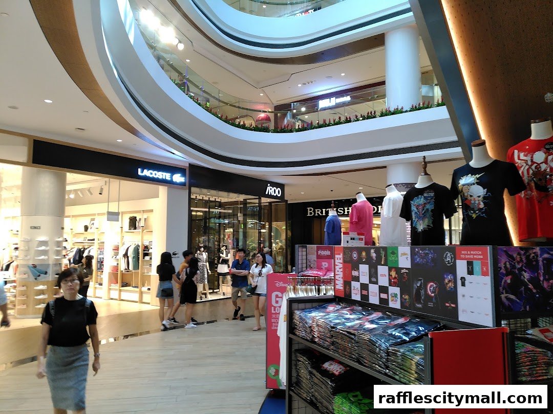 A shopping mall interior with various stores and mannequins displaying t-shirts.