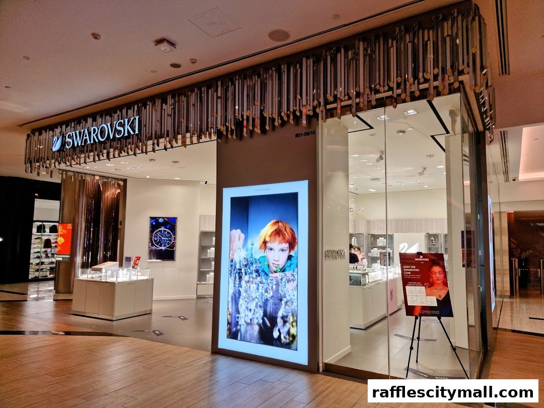 The exterior of a modern Swarovski store with a large illuminated display and glass entrance.