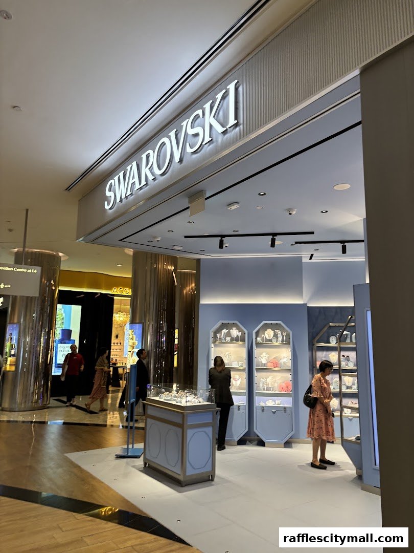 The entrance of a Swarovski store with illuminated signage and display cases showcasing jewelry.