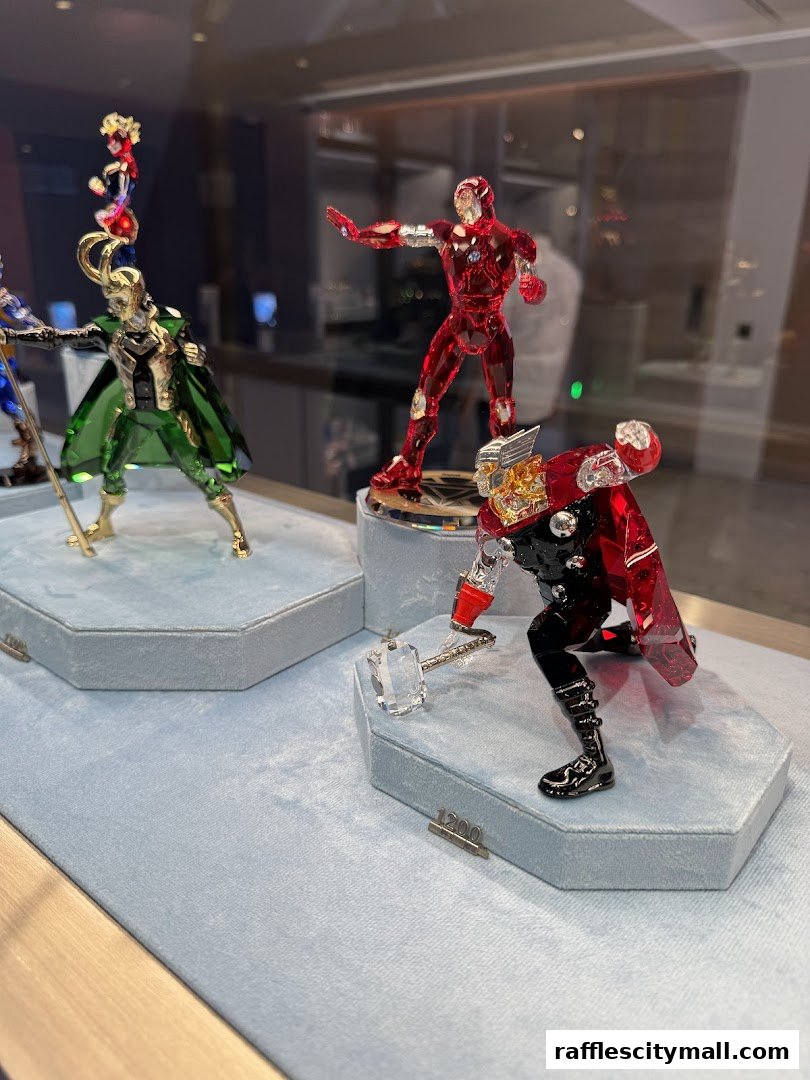 Swarovski crystal figurines of Marvel characters Iron Man, Loki, Thor, and Captain Marvel displayed.