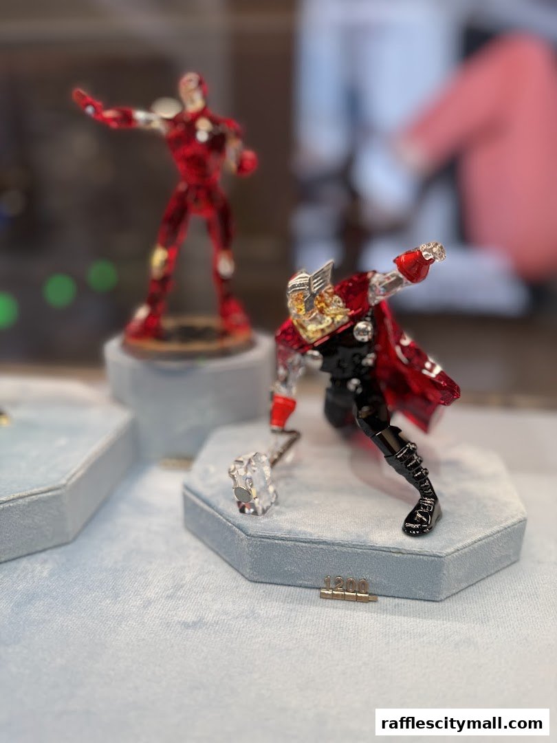 Swarovski crystal figurines of Iron Man and Thor displayed in a shop.